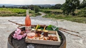 Bouteille de rosé et planche apéritif posés sur un tonneau en bois